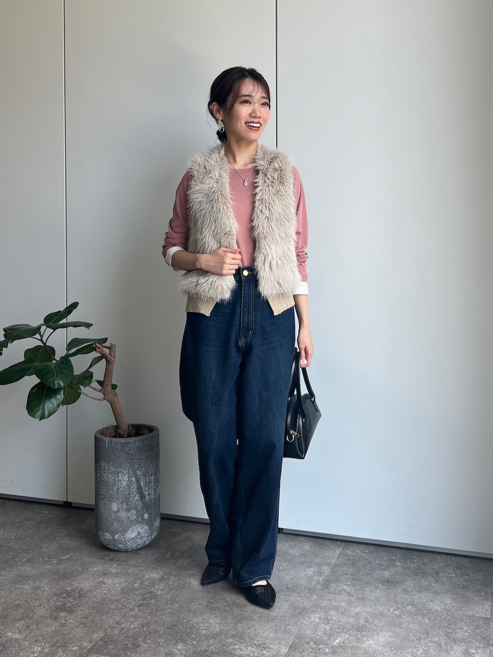ベージュ系のベスト、ピンク系のTシャツ/カットソー、ブルー系のデニムパンツを着用したレディースの夏コーディネートの2枚目の写真
