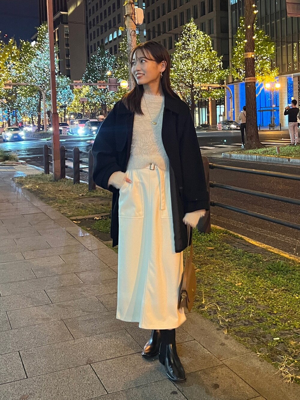 ブラック系のその他アウター、ホワイト系のニット/セーター、ホワイト系のスカートを着用したレディースの秋コーディネートの2枚目の写真