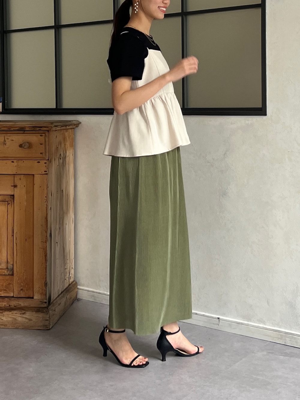 ホワイト系のワンピース、ブラック系のTシャツ/カットソー、グリーン系のスカートを着用したレディースの春コーディネートの3枚目の写真