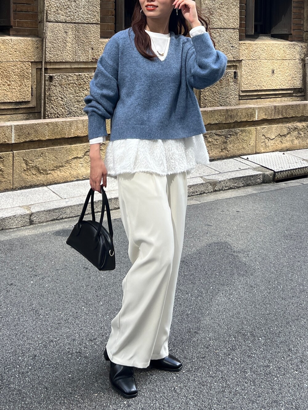 ブルー系のニット/セーター、ブラック系のトートバッグ、ホワイト系のその他パンツを着用したレディースの冬コーディネートの2枚目の写真