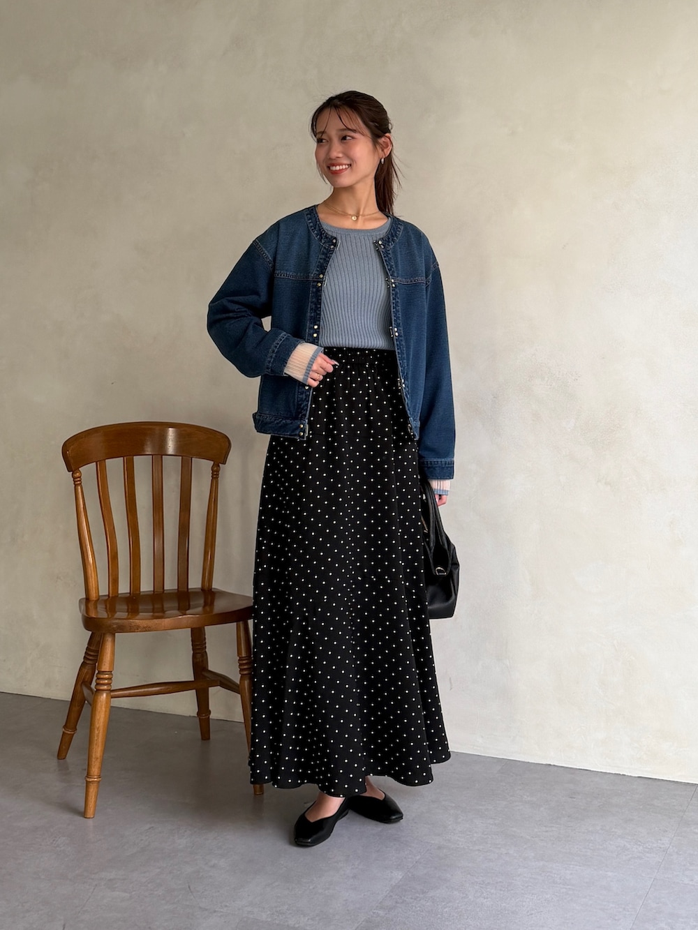 ブルー系のブルゾン、ブルー系のニット/セーター、ブラック系のスカートを着用したレディースの春コーディネートの5枚目の写真