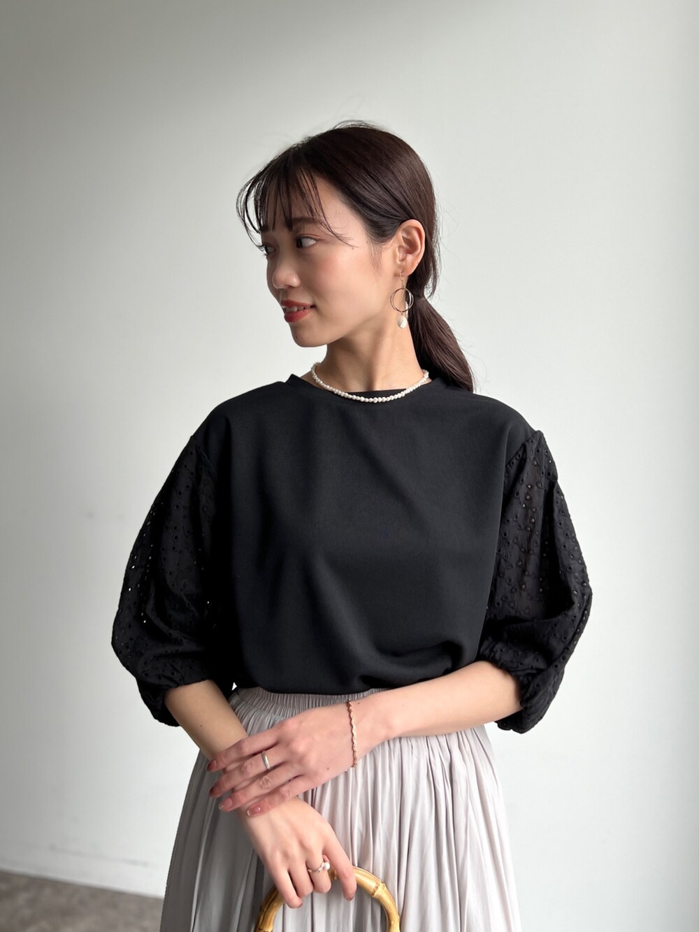 ブラック系のTシャツ/カットソー、ベージュ系のその他パンツ、グレー系のサンダルを着用したレディースの春コーディネートの2枚目の写真