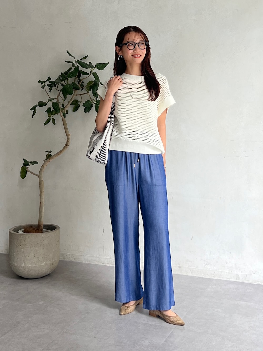 ホワイト系のニット/セーター、ブラック系のトートバッグ、ブルー系のその他パンツを着用したレディースの夏コーディネートの4枚目の写真