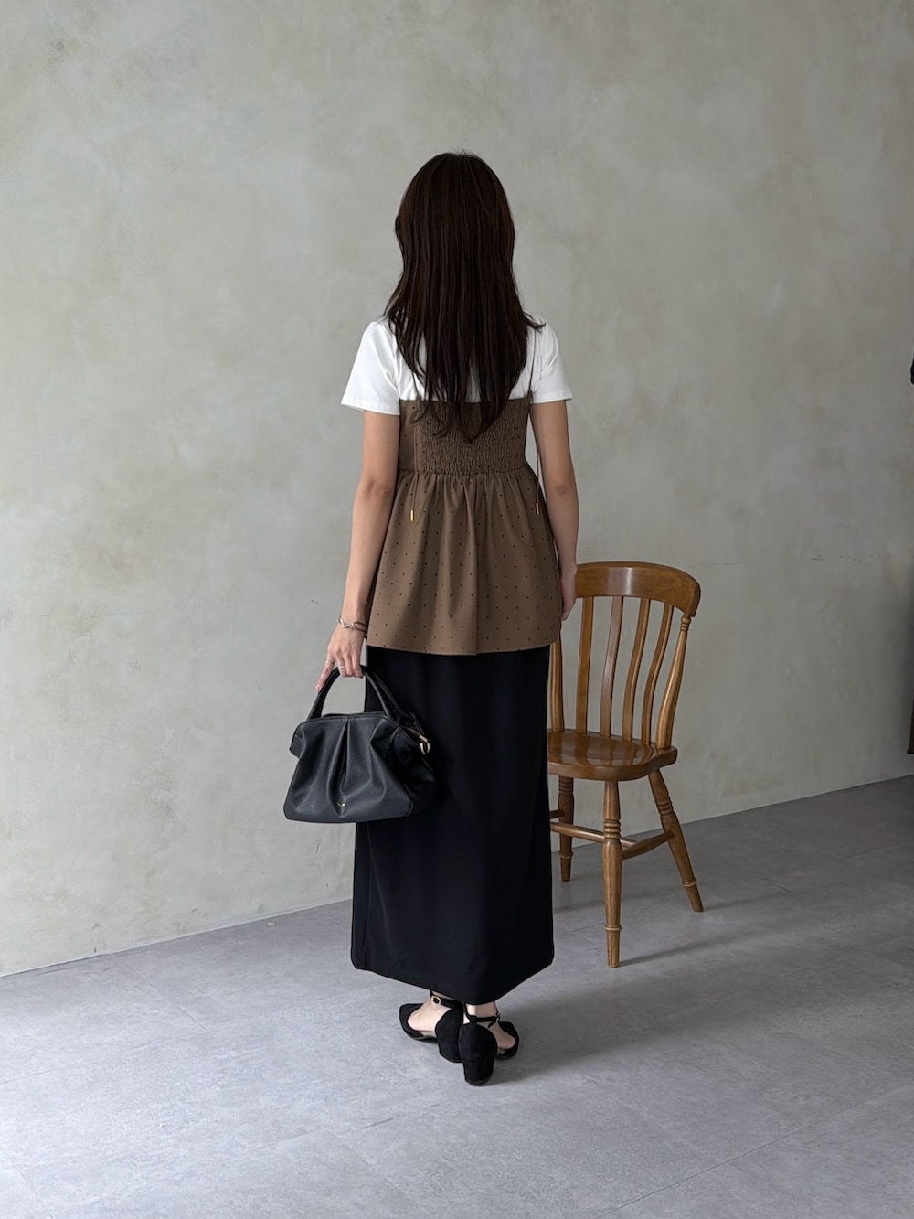 イエロー系のシャツ/ブラウス、ブラック系のボストンバッグ、ブラック系のスカートを着用したレディースの秋コーディネートの3枚目の写真