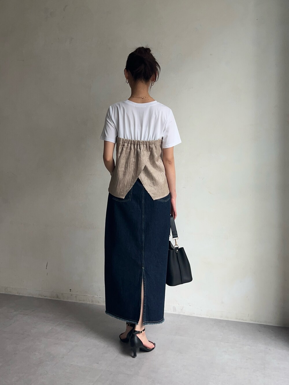 ベージュ系のTシャツ/カットソー、ブルー系のデニムスカート、ブラック系のシューズを着用したレディースの春コーディネートの4枚目の写真
