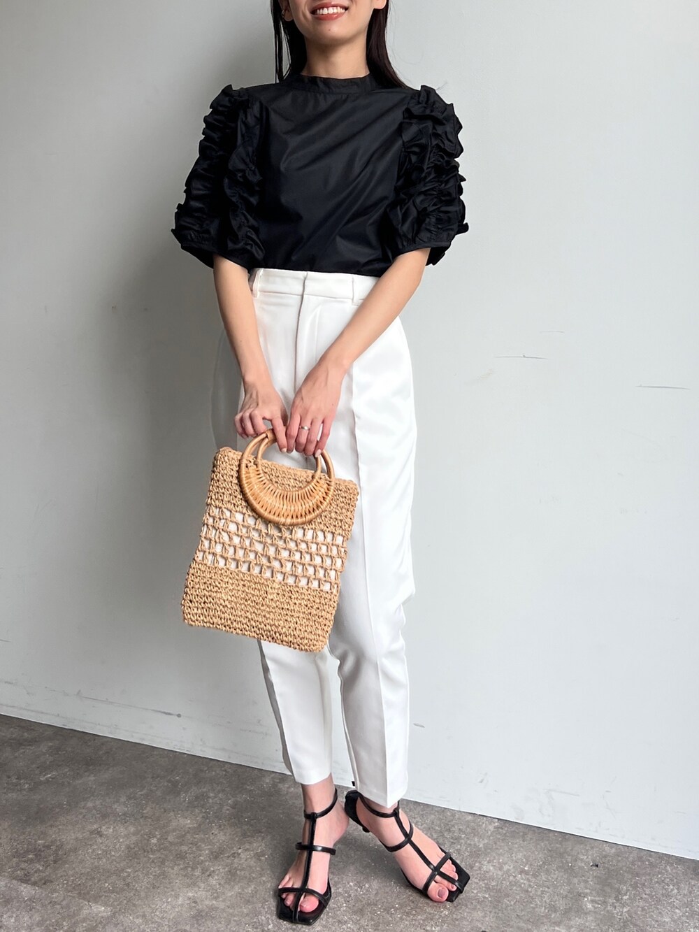 ブラック系のシャツ/ブラウス、イエロー系のかごバッグ、ブラック系のサンダルを着用したレディースの夏コーディネートの2枚目の写真