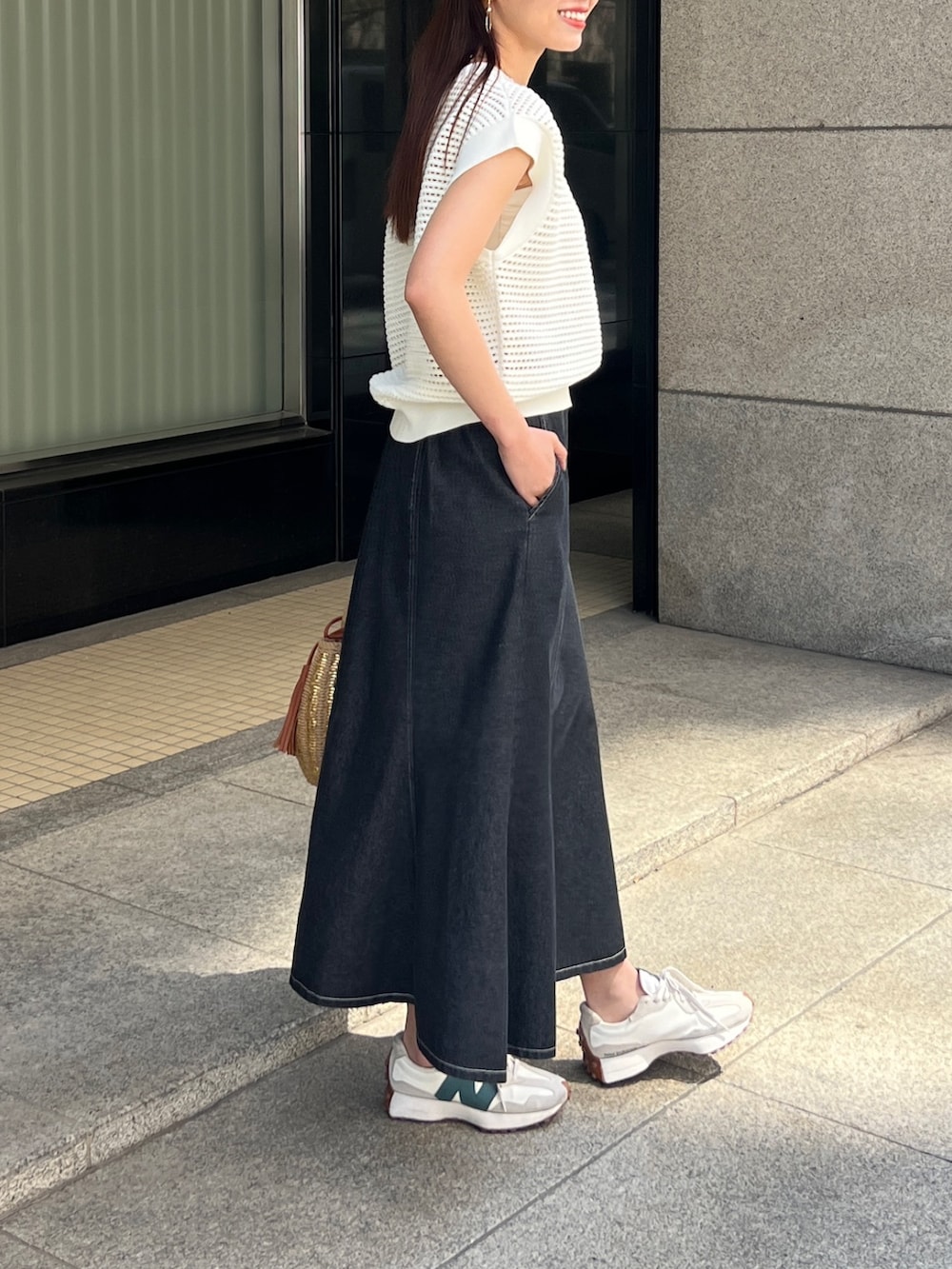 ホワイト系のニット/セーター、ブラック系のスカート、ベージュ系のかごバッグを着用したレディースの春コーディネートの3枚目の写真