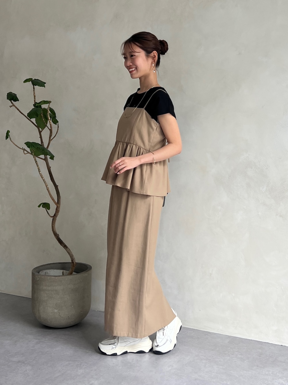 ベージュ系のワンピース、ブラック系のTシャツ/カットソー、ホワイト系のスニーカーを着用したレディースの夏コーディネートの4枚目の写真