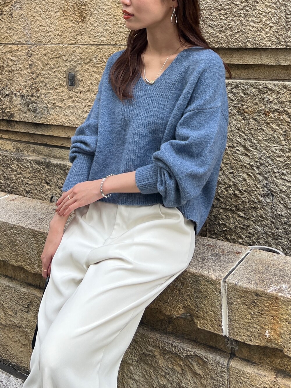 ブルー系のニット/セーター、ブラック系のトートバッグ、ホワイト系のその他パンツを着用したレディースの冬コーディネートの4枚目の写真