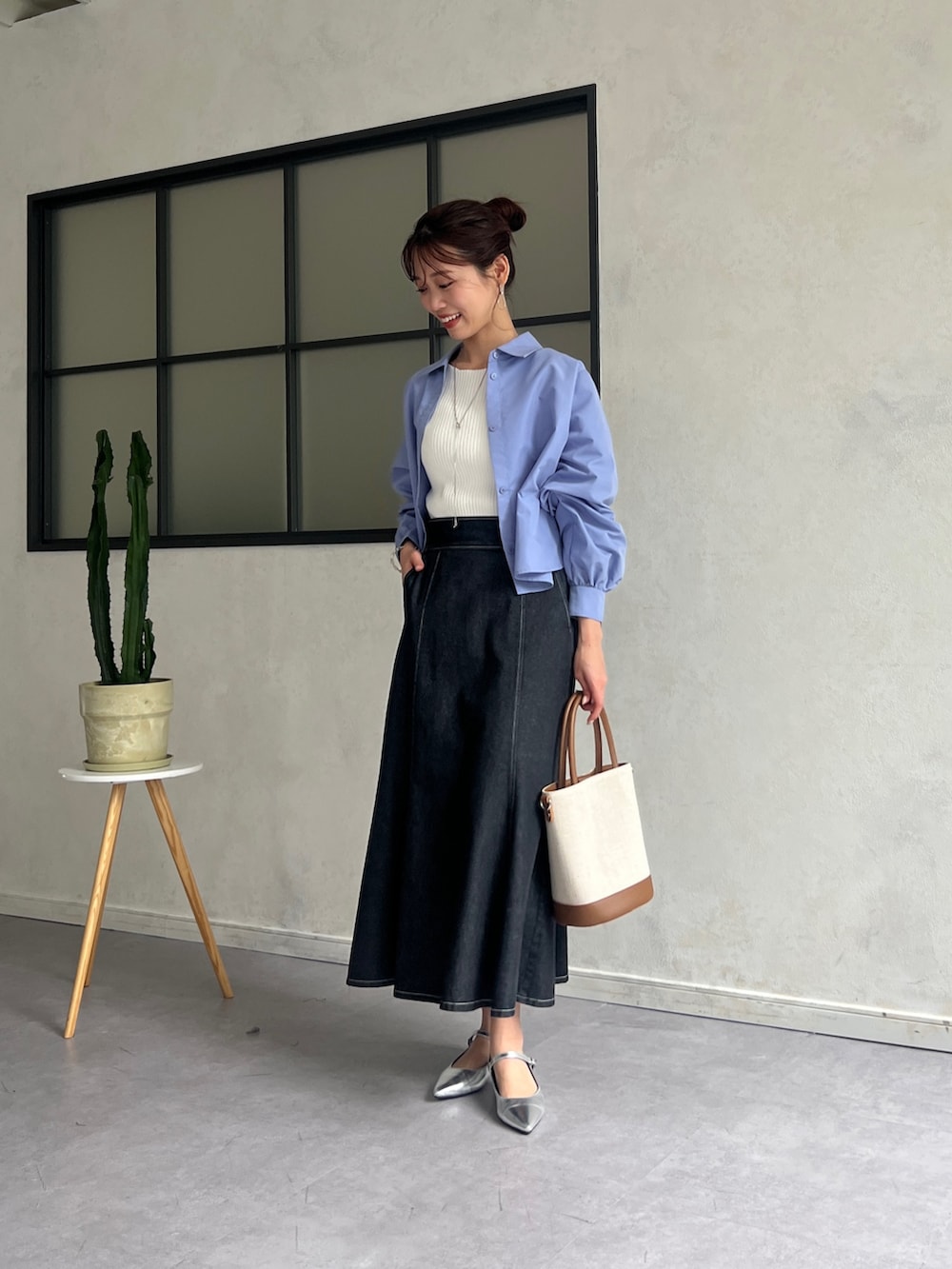 ブルー系のシャツ/ブラウス、ホワイト系のニット/セーター、ブラック系のスカートを着用したレディースの春コーディネートの2枚目の写真