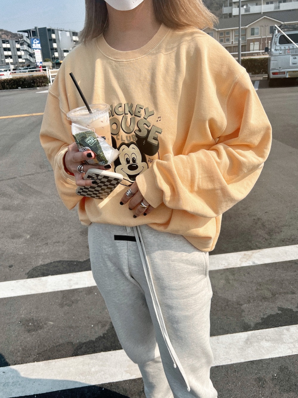 イエロー系のスウェット、シルバー系のスニーカーを着用したレディースの春コーディネートの2枚目の写真