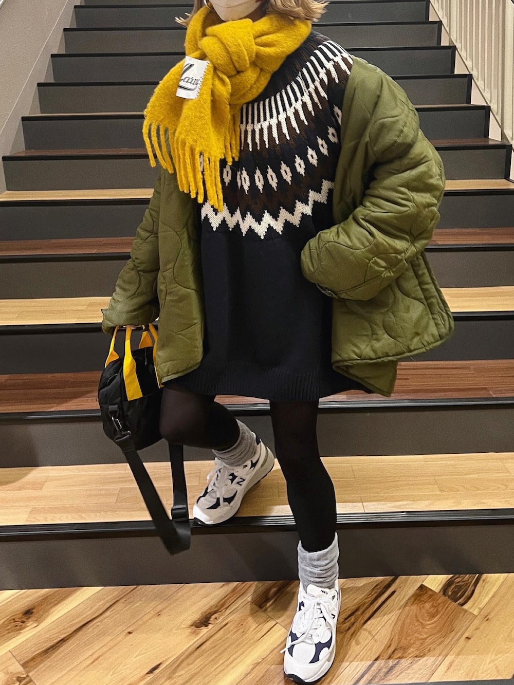 ブラック系のトートバッグ、グリーン系のジャケット/アウター、ホワイト系のスニーカーを着用したレディースの冬コーディネートの2枚目の写真