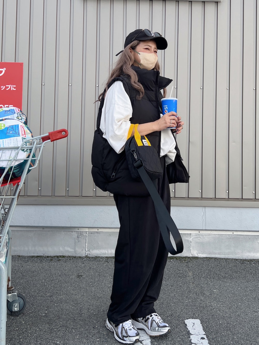 ブラック系のダウンベスト、ホワイト系のTシャツ/カットソー、シルバー系のスニーカーを着用したレディースの秋コーディネートの3枚目の写真