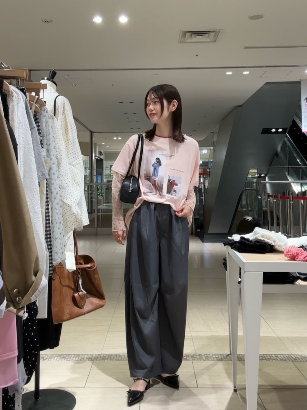 ピンク系のTシャツ/カットソー、グレー系のスラックス、ブラック系のパンプスを着用したレディースの春コーディネートの2枚目の写真