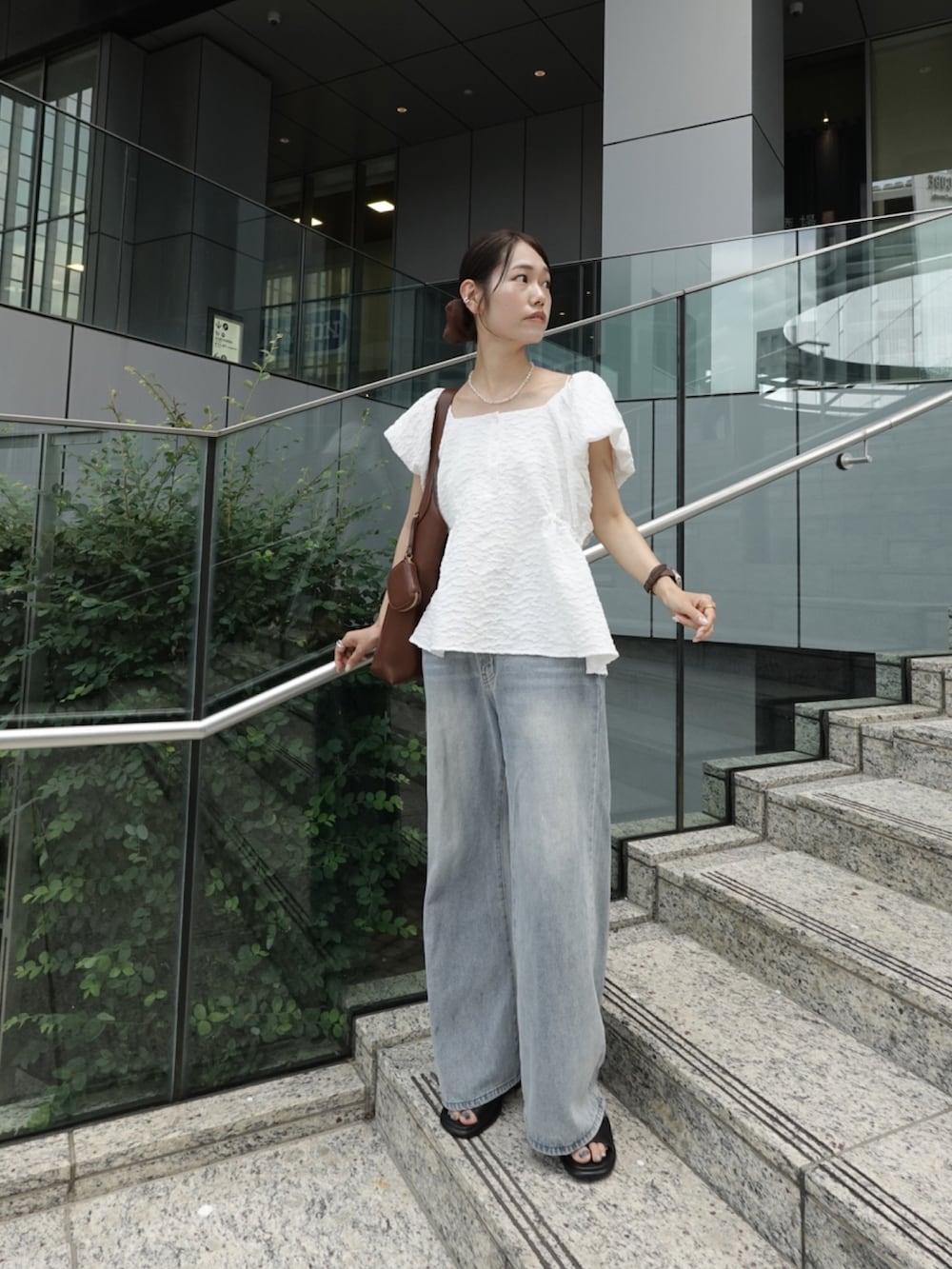 ホワイト系のシャツ/ブラウス、ブルー系のデニムパンツ、ブラウン系のトートバッグを着用したレディースの夏コーディネートの2枚目の写真