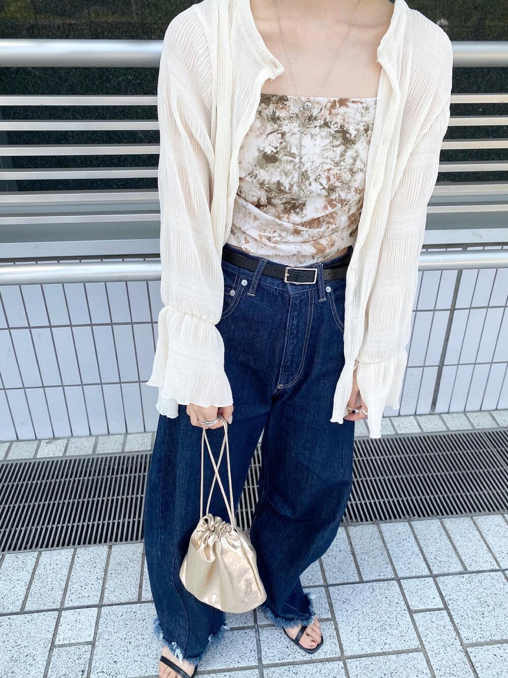 ブルー系のデニムパンツ、グリーン系のキャミソール、ホワイト系のシャツ/ブラウスを着用したレディースの春コーディネートの2枚目の写真