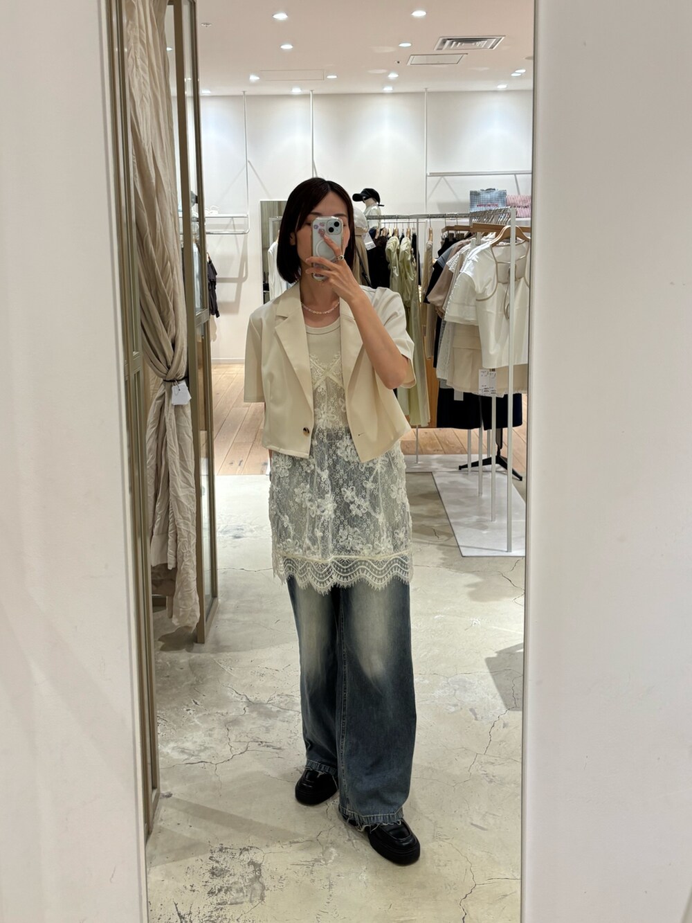 ベージュ系のその他アウター、ホワイト系のシャツ/ブラウス、ブルー系のデニムパンツを着用したレディースの春コーディネートの2枚目の写真