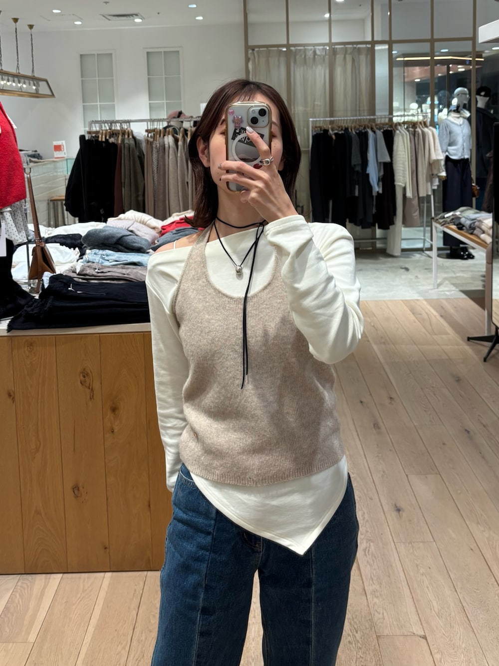 ブルー系のデニムパンツ、ベージュ系のTシャツ/カットソーを着用したレディースの冬コーディネートの2枚目の写真