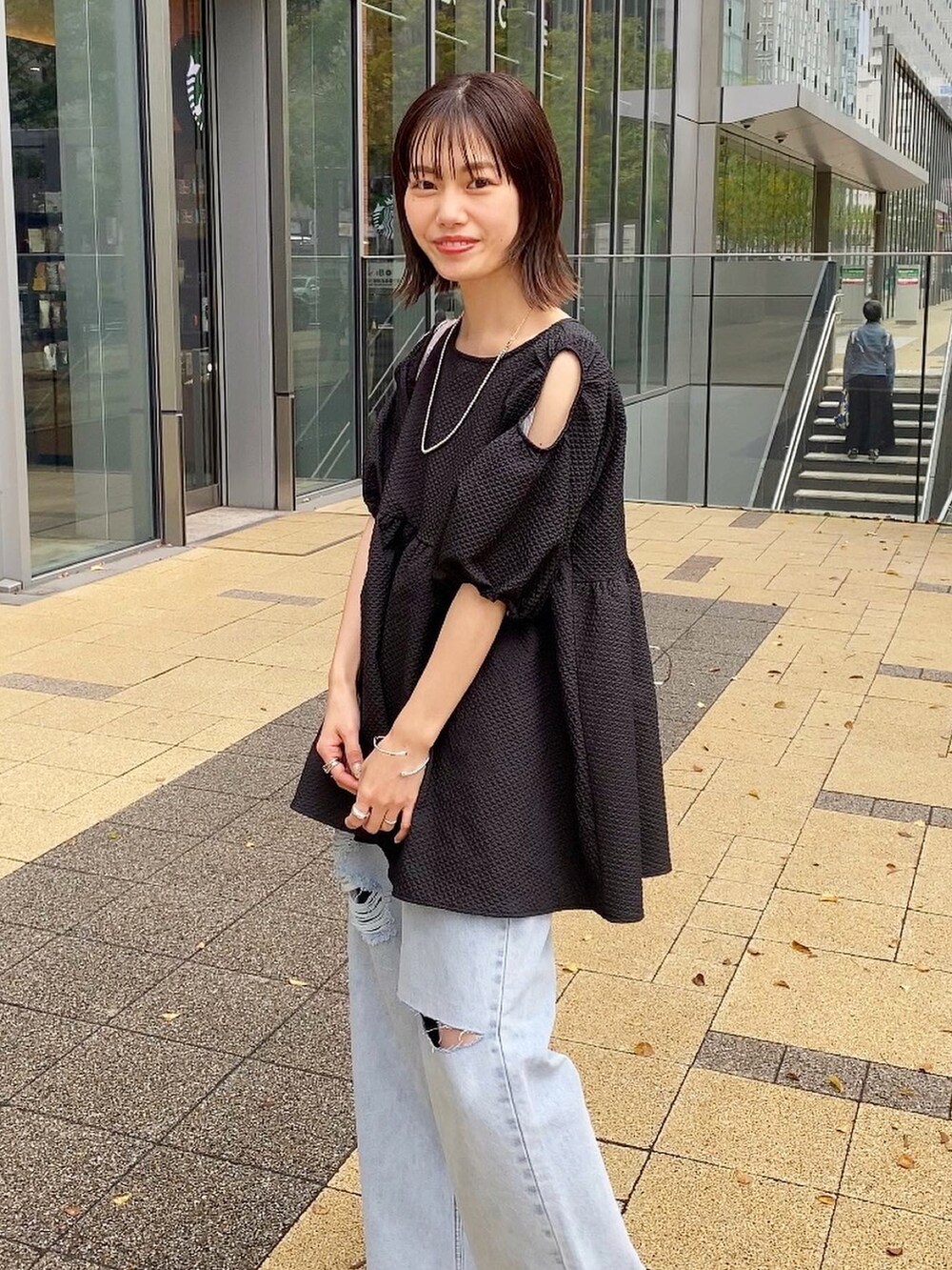 ブラック系のシャツ/ブラウス、ブルー系のデニムパンツを着用したレディースの春コーディネートの2枚目の写真