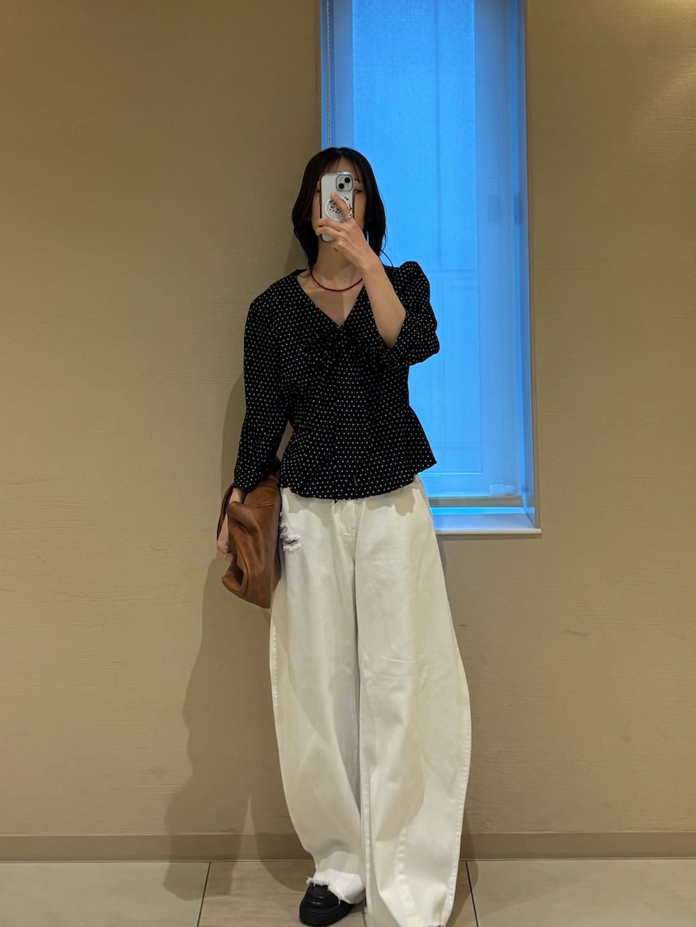 ブラック系のシャツ/ブラウス、イエロー系のトートバッグ、ホワイト系のデニムパンツを着用したレディースの春コーディネートの2枚目の写真