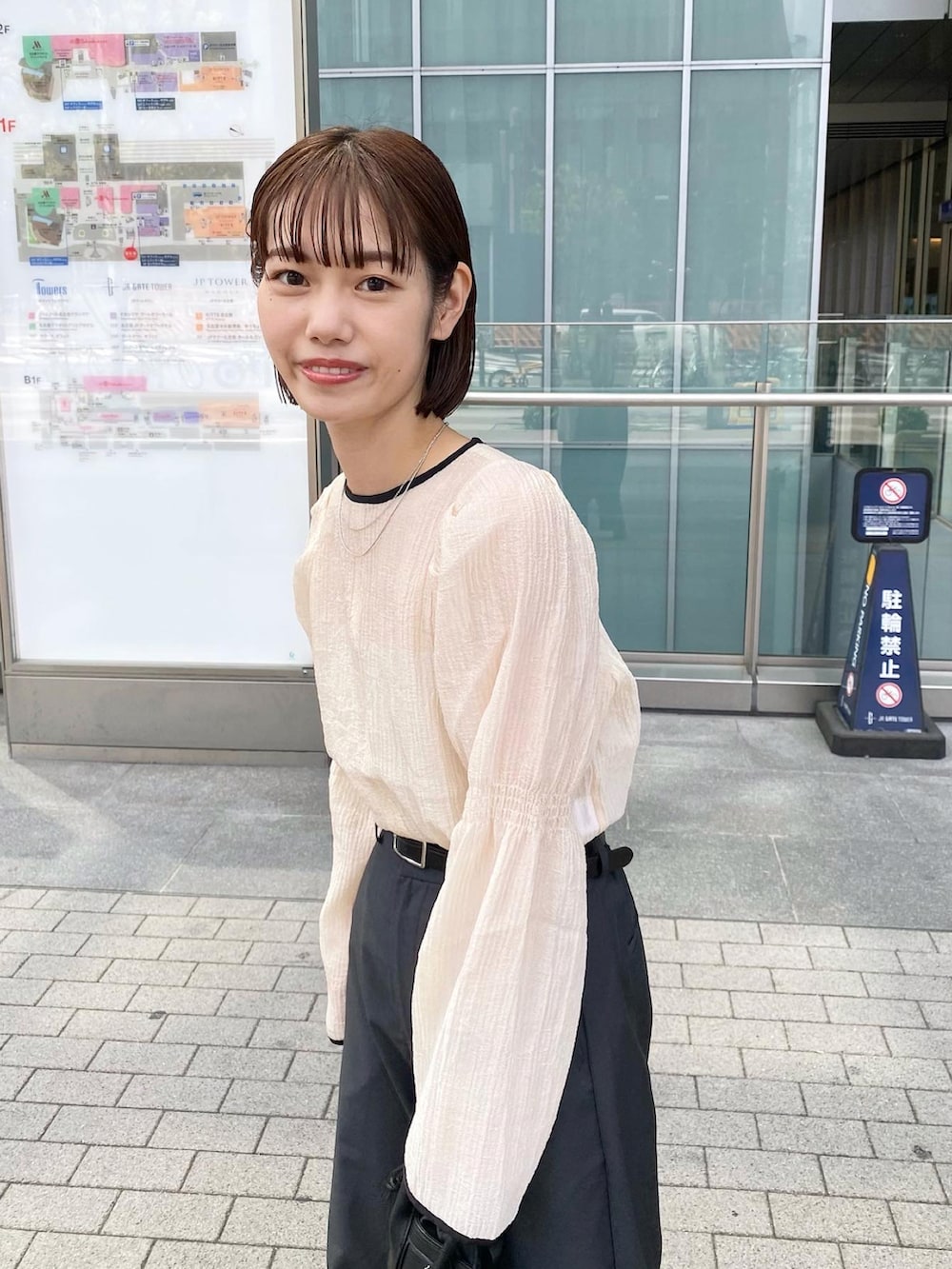 ベージュ系のシャツ/ブラウス、グレー系のスラックス、ブラック系のローファーを着用したレディースの夏コーディネートの3枚目の写真