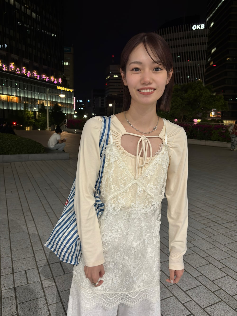 ベージュ系のTシャツ/カットソー、ホワイト系のトップス、グレー系のスウェットパンツを着用したレディースの春コーディネートの2枚目の写真