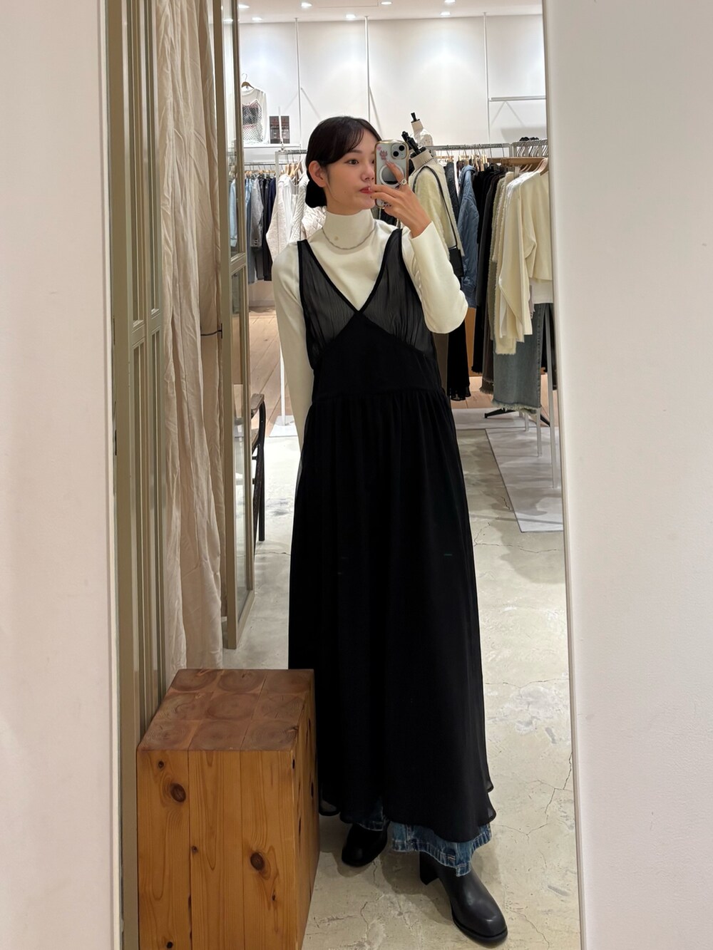 ホワイト系のニット/セーター、グレー系のワンピース、ブルー系のデニムパンツを着用したレディースの冬コーディネートの2枚目の写真