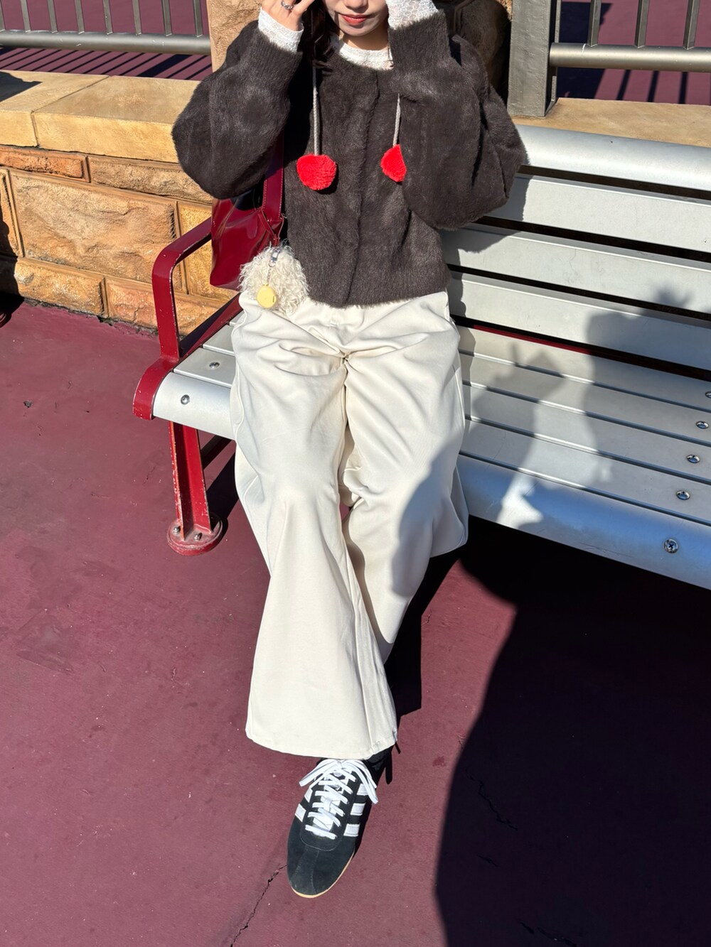 ブラウン系のカーディガン/ボレロ、ホワイト系のTシャツ/カットソー、ホワイト系のスラックスを着用したレディースの冬コーディネートの3枚目の写真