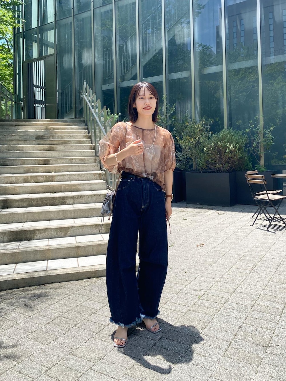 ブラウン系のシャツ/ブラウス、ブルー系のデニムパンツを着用したレディースの夏コーディネートの3枚目の写真