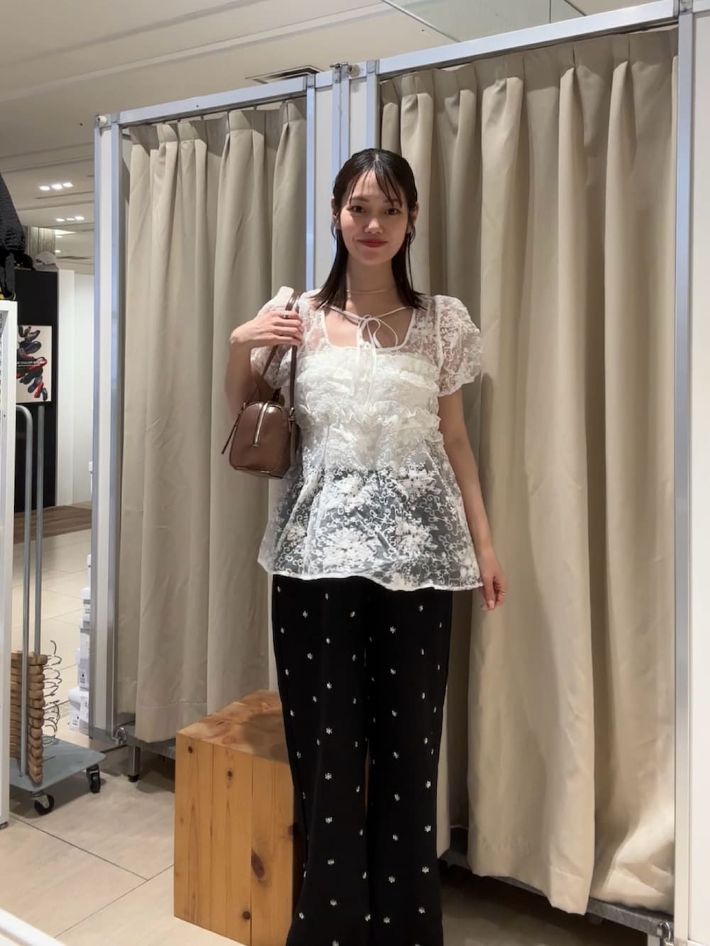 ブラック系のスラックス、ホワイト系のシャツ/ブラウス、イエロー系のボストンバッグを着用したレディースの春コーディネートの2枚目の写真