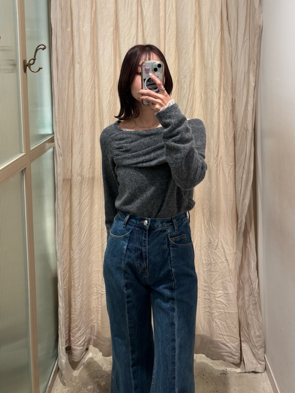 ホワイト系のTシャツ/カットソー、グレー系のニット/セーター、ブルー系のデニムパンツを着用したレディースの冬コーディネートの2枚目の写真