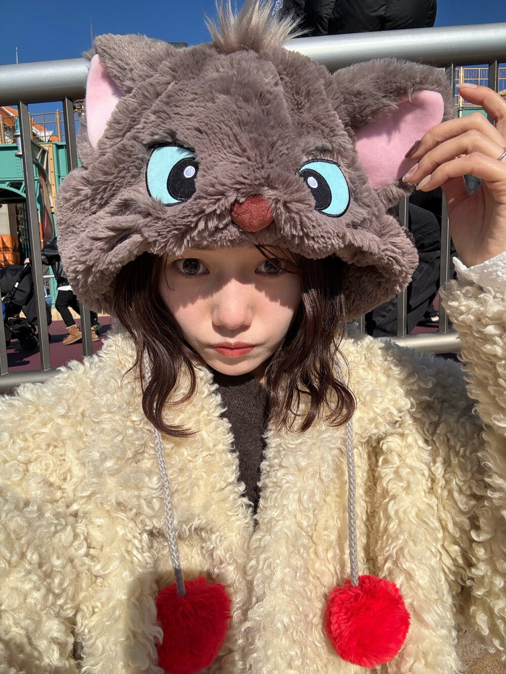 ブラウン系のカーディガン/ボレロ、ホワイト系のTシャツ/カットソー、ホワイト系のスラックスを着用したレディースの冬コーディネートの2枚目の写真