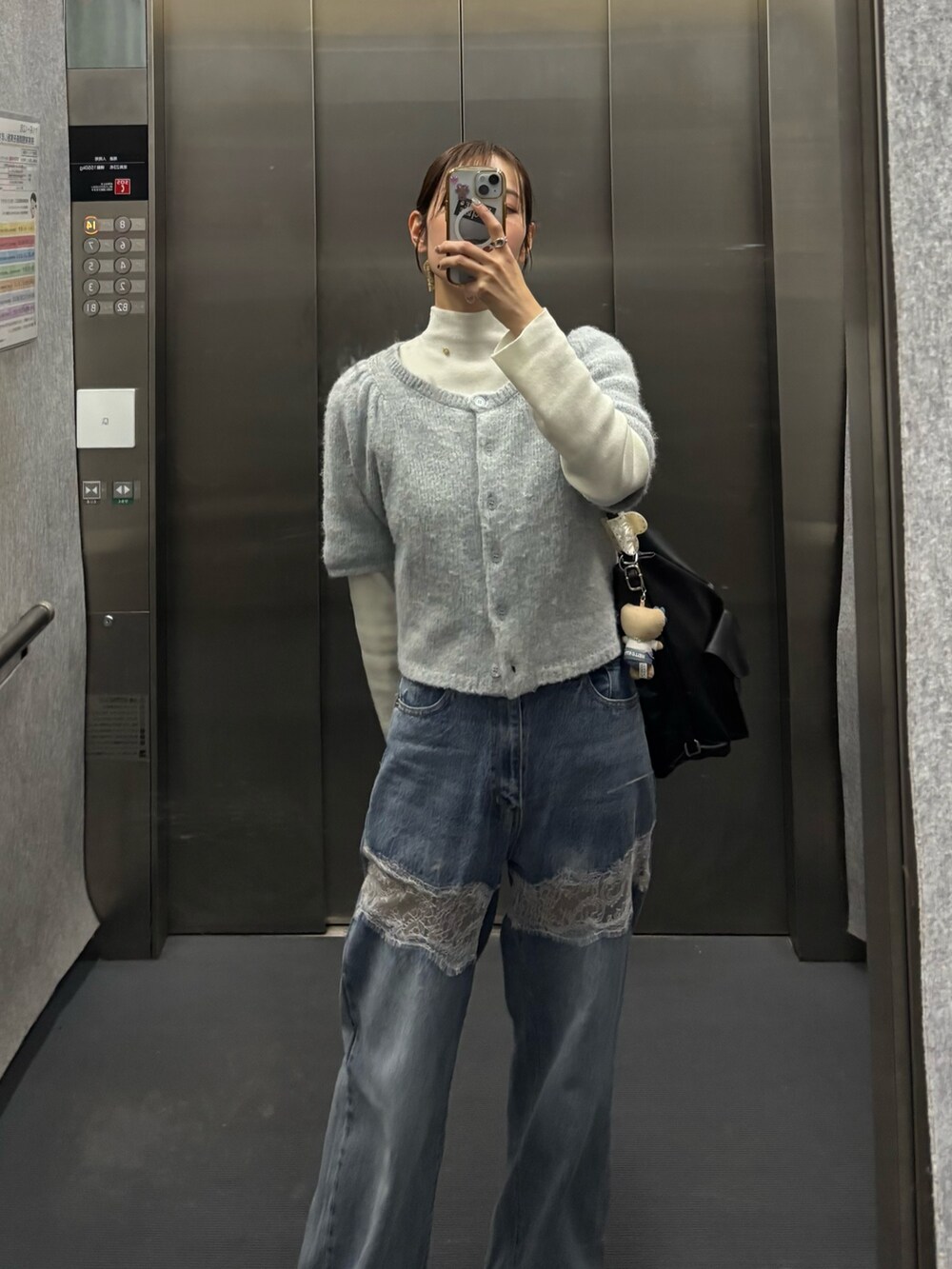 ブルー系のカーディガン/ボレロ、ホワイト系のニット/セーター、ブルー系のデニムパンツを着用したレディースの冬コーディネートの2枚目の写真