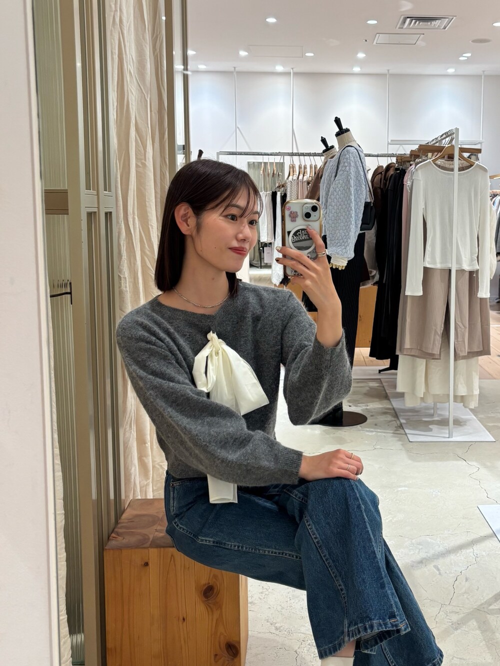 グレー系のニット/セーター、ブルー系のデニムパンツを着用したレディースの冬コーディネートの2枚目の写真