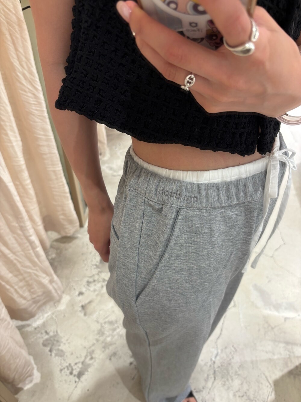 ブラック系のタンクトップ、グレー系のスウェットパンツ、ブラック系のサンダルを着用したレディースの夏コーディネートの2枚目の写真