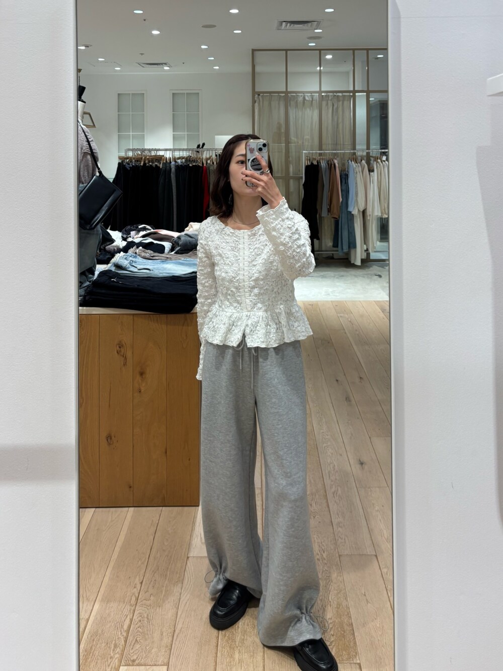 ホワイト系のシャツ/ブラウス、グレー系のスウェットパンツを着用したレディースの冬コーディネートの2枚目の写真