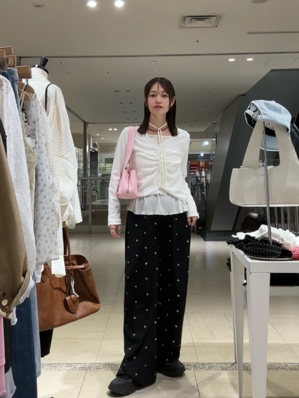 ホワイト系のTシャツ/カットソー、ホワイト系のTシャツ/カットソー、ピンク系のハンドバッグを着用したレディースの春コーディネートの2枚目の写真