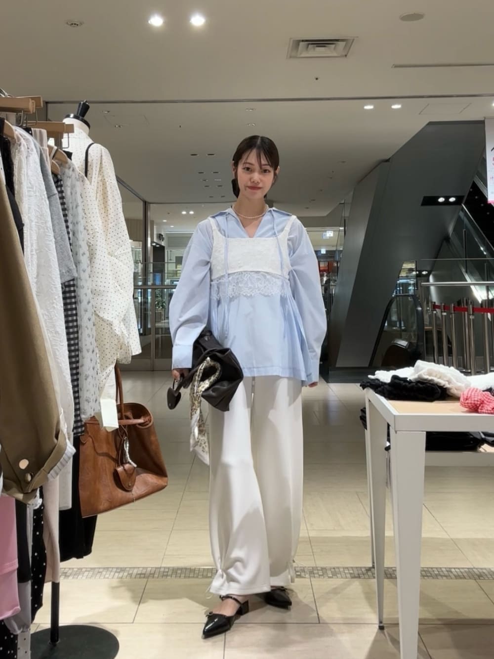 ホワイト系のスウェットパンツ、ブラック系のパンプス、ブラウン系のトートバッグを着用したレディースの春コーディネートの2枚目の写真