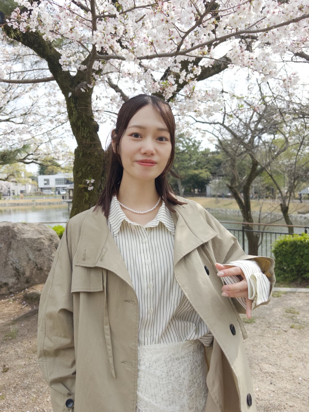 ブラウン系のシャツ/ブラウス、ホワイト系のスカート、ブラック系のトートバッグを着用したレディースの春コーディネートの2枚目の写真