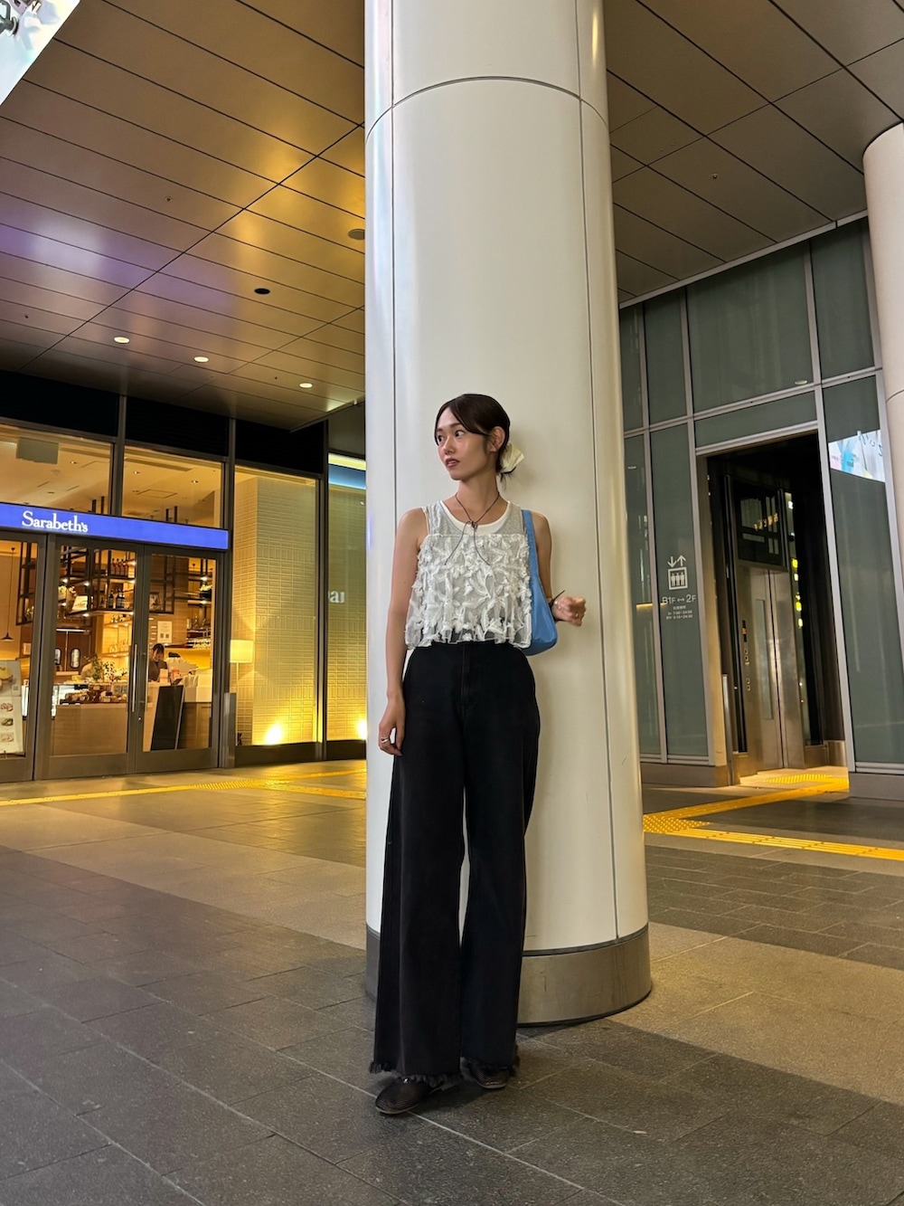 ブラック系のデニムパンツ、ブラック系のパンプス、グレー系のタンクトップを着用したレディースの夏コーディネートの2枚目の写真