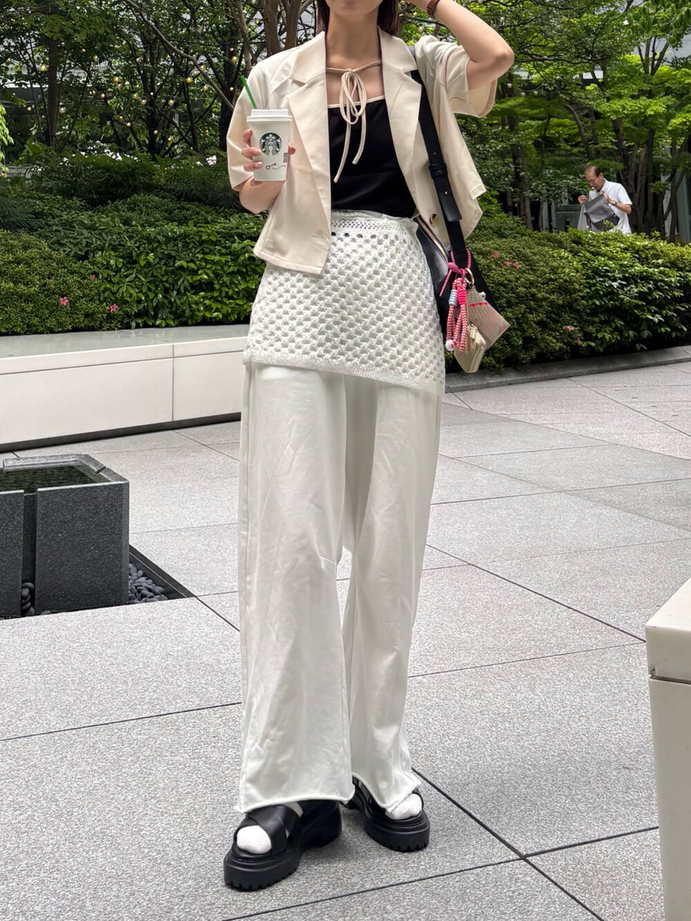 ベージュ系のその他アウター、ブラック系のTシャツ/カットソー、ホワイト系のスカートを着用したレディースの春コーディネートの2枚目の写真