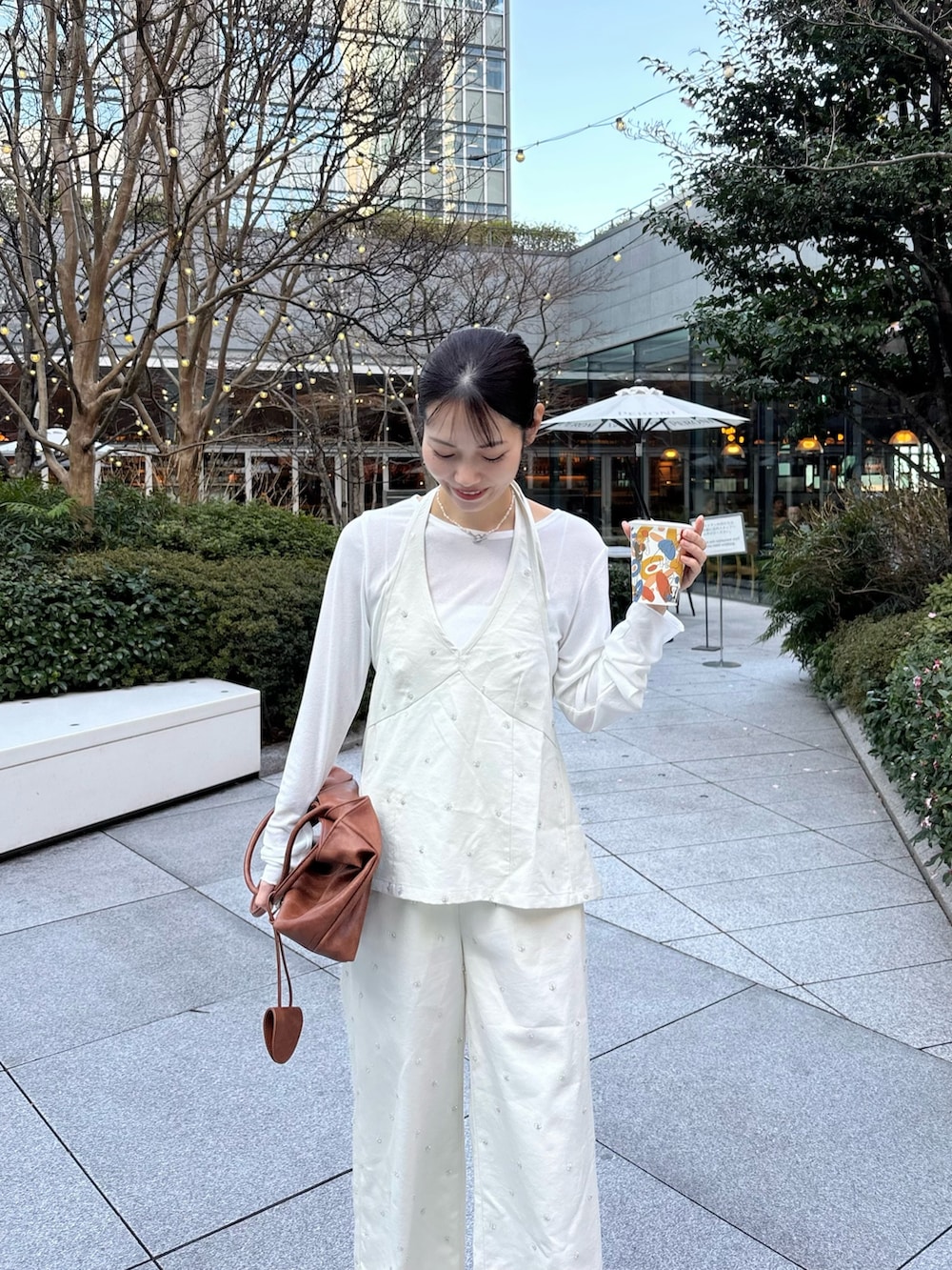 イエロー系のトートバッグ、ホワイト系のTシャツ/カットソー、ホワイト系のシャツ/ブラウスを着用したレディースの春コーディネートの2枚目の写真