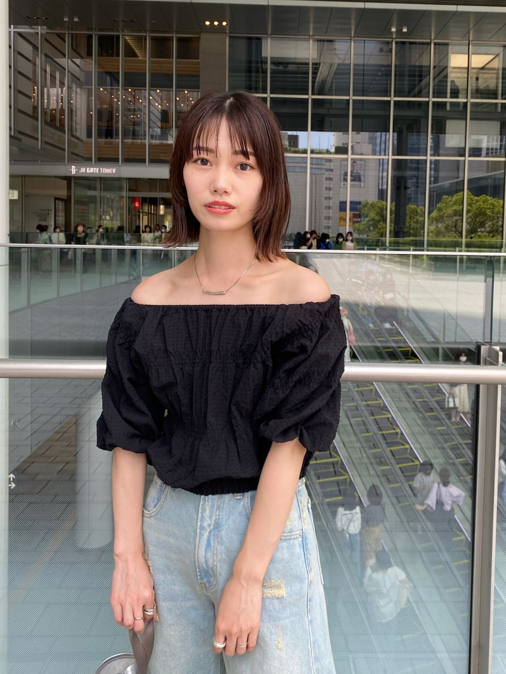 ブルー系のデニムパンツ、ブラック系のシャツ/ブラウスを着用したレディースの春コーディネートの3枚目の写真