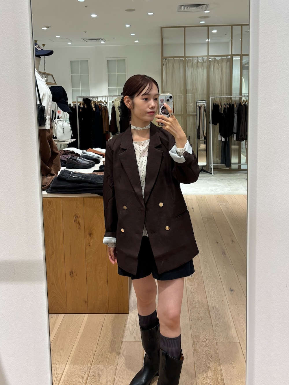 ブラウン系のテーラードジャケット、ホワイト系のTシャツ/カットソー、ブラック系のブーツを着用したレディースの秋コーディネートの2枚目の写真