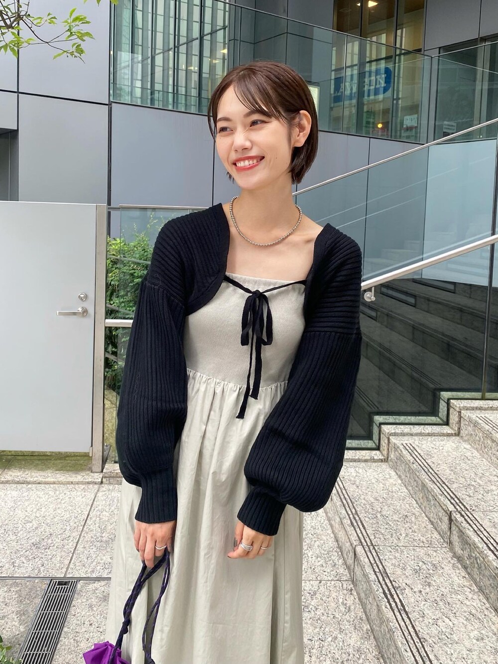 ベージュ系のワンピース、ブラック系のスリッポンを着用したレディースの夏コーディネートの2枚目の写真