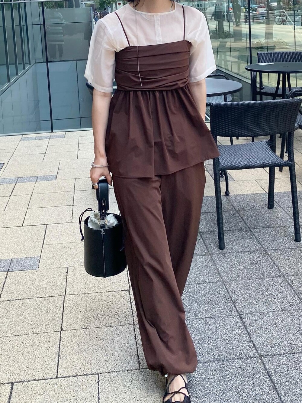 ブラック系のハンドバッグ、ブラウン系のトップス、ホワイト系のシャツ/ブラウスを着用したレディースの夏コーディネートの3枚目の写真