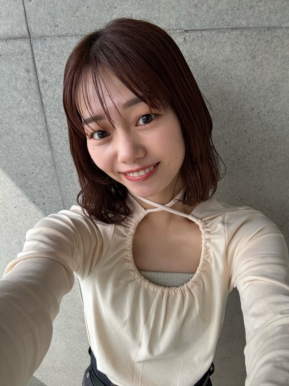 ベージュ系のTシャツ/カットソー、ブルー系のデニムパンツを着用したレディースの春コーディネートの3枚目の写真