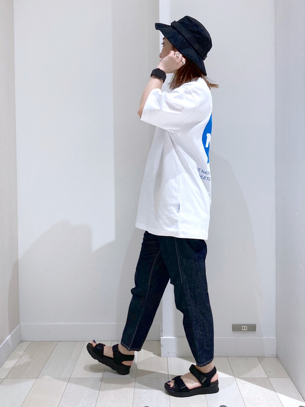 ブルー系のデニムパンツ、その他のサンダル、ベージュ系のショルダーバッグを着用したレディースの夏コーディネートの3枚目の写真