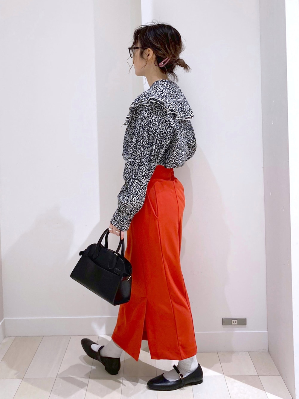 ブラック系のショルダーバッグ、ブラック系のシャツ/ブラウス、レッド系のスカートを着用したレディースの春コーディネートの2枚目の写真