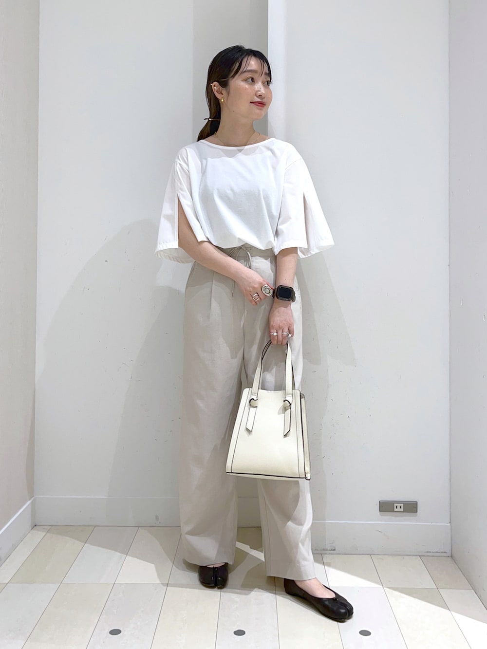 ホワイト系のショルダーバッグ、ベージュ系のその他パンツ、ブラック系のバレエシューズを着用したレディースの春コーディネートの2枚目の写真